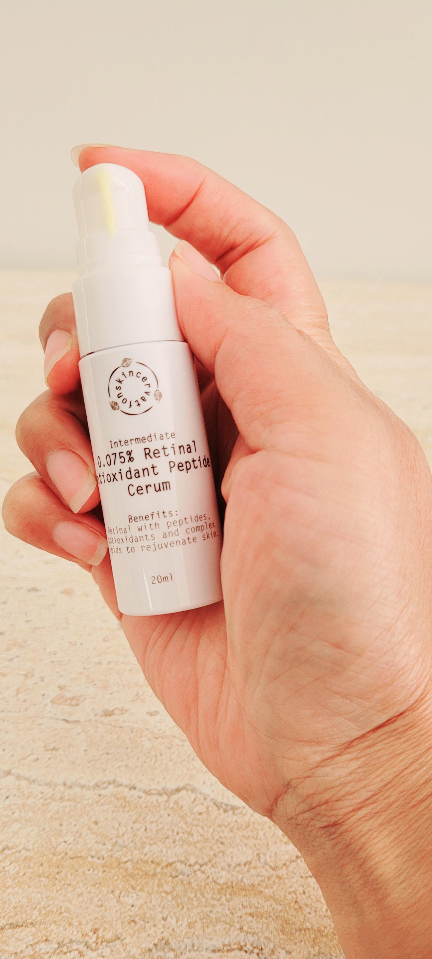 Hand holding skincervation Intermediate Retinal Antioxidant Peptide Anti-Ageing serum bottle
