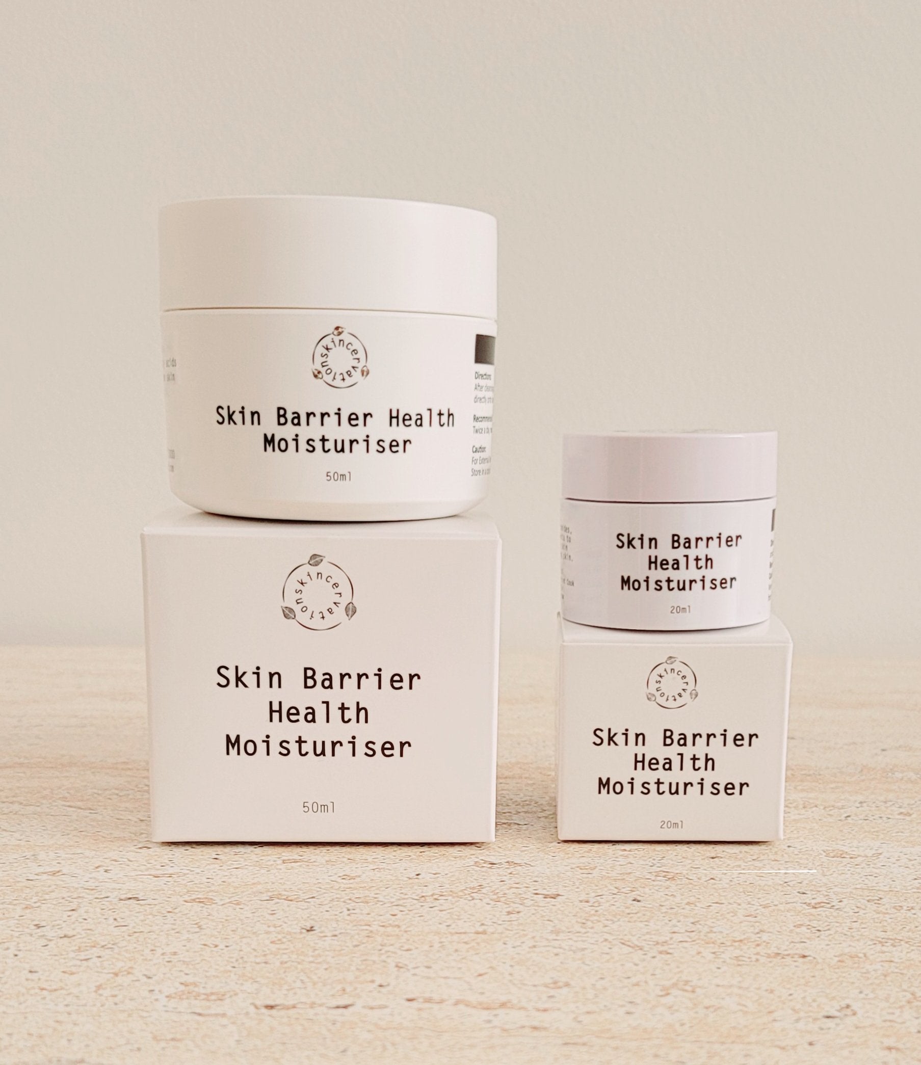 Two Jars of ceramide moisturiser sitting on top of two boxes 20ml and 50ml