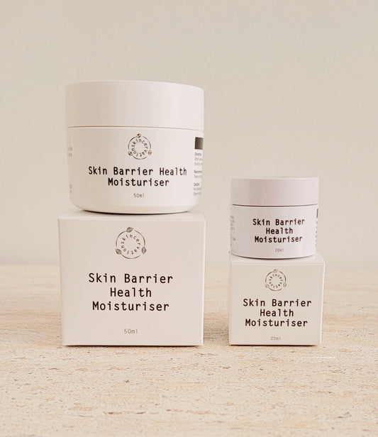 Two Jars of ceramide moisturiser sitting on top of two boxes 20ml and 50ml