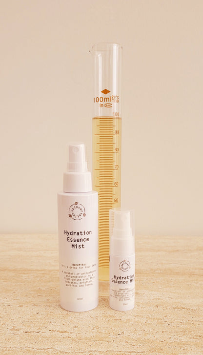 Two bottles of various sizes of  various sizes of Skincervation Hydration Essence Mist and a scientific measurig instrument filled with high grade essence.