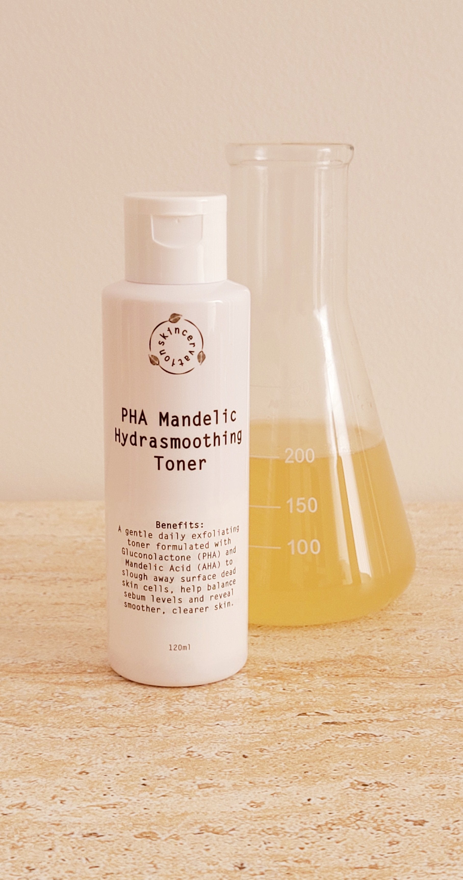 A Bottle of pHA Mandelic Hydrating Toner standing next scientific beaker with yellow liquid